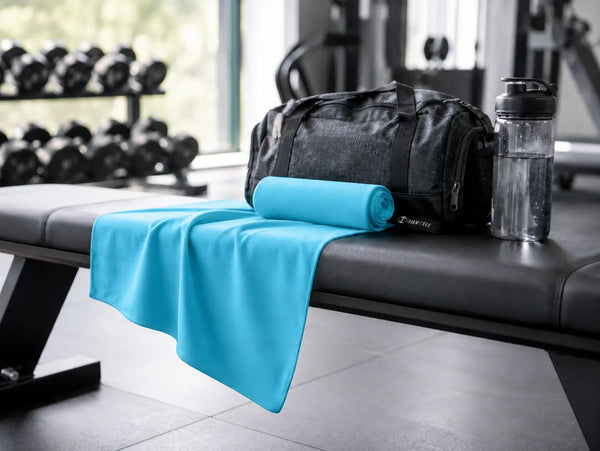 Mikrofaser-Sporthandtuch liegt auf einer Hantelbank im Fitnessstudio